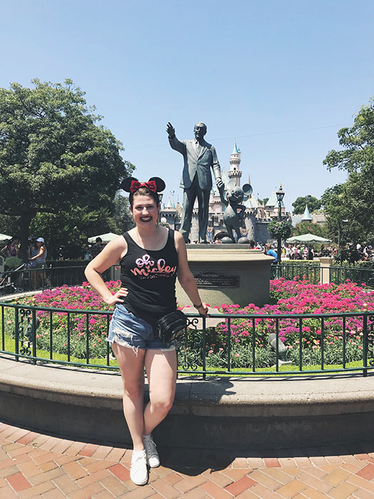 Standing in front of a statue of the man himself, Walt Disney.